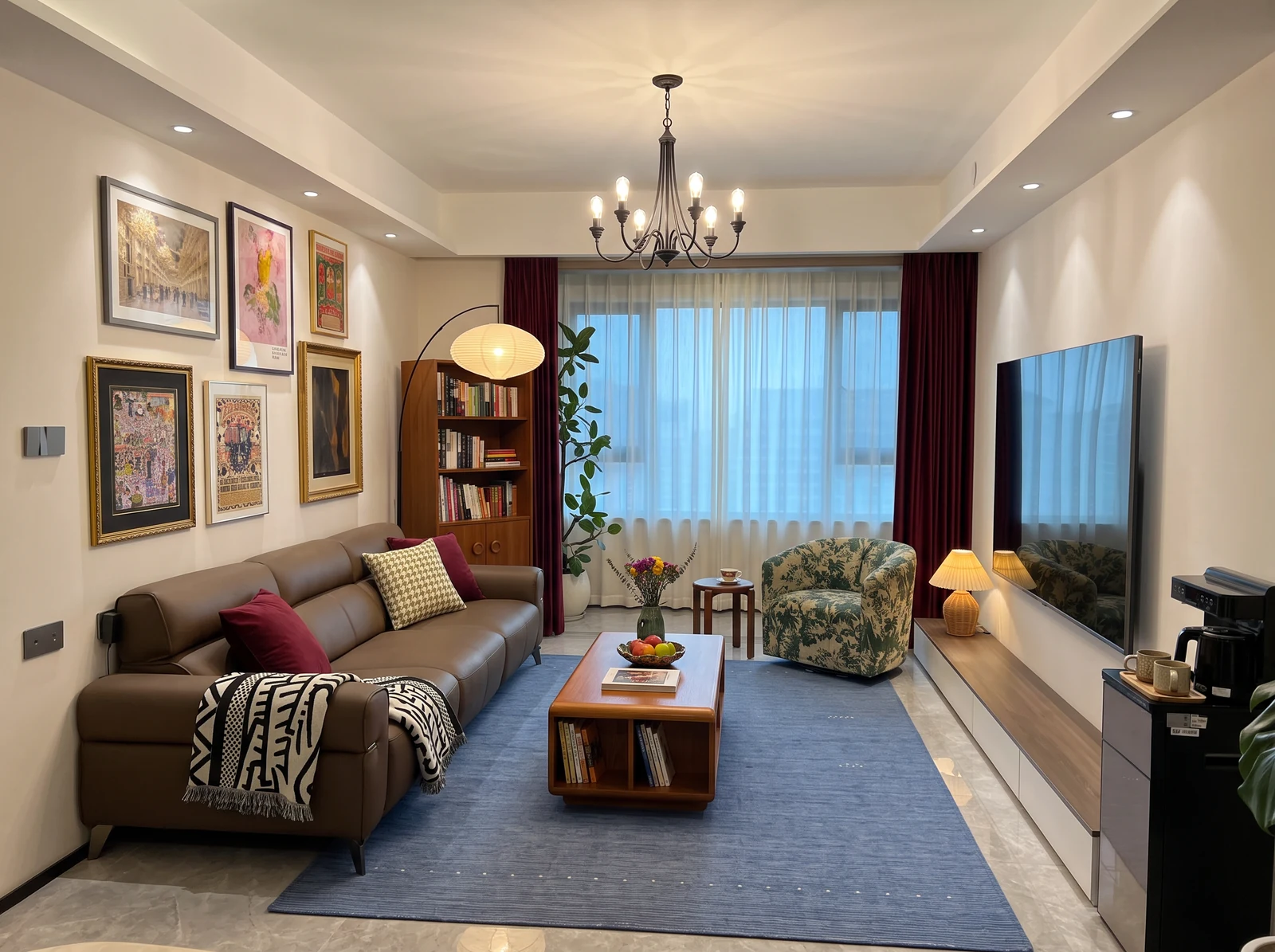 Proposed collected living room with brown leather sofa, burgundy curtains, blue rug, floral chair, wood coffee table, gallery wall and shelving.