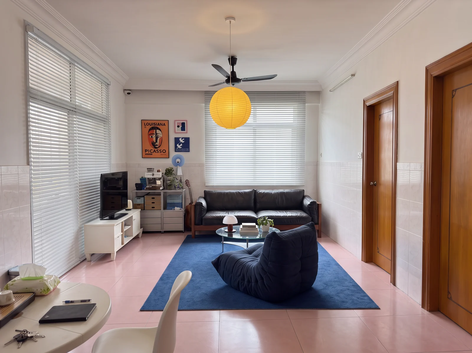 Proposed blue and chrome living room with dark sofa, blue rug and lounge chair around the existing pink tile.